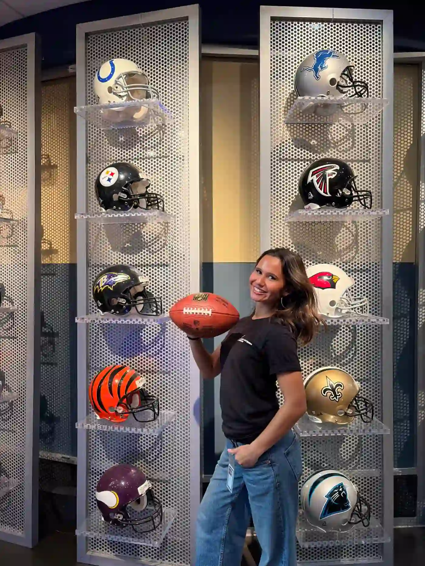 holding a football in front of nfl helmets